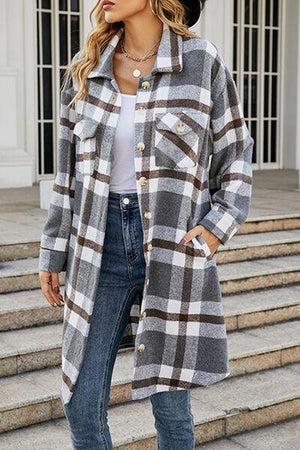 a woman standing on steps wearing a plaid coat