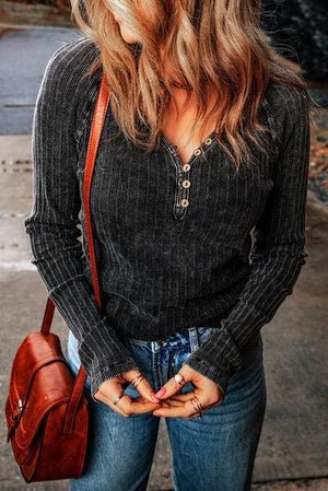 a woman standing on a sidewalk with her hands in her pockets