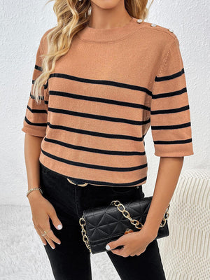 a woman wearing a tan and black striped sweater