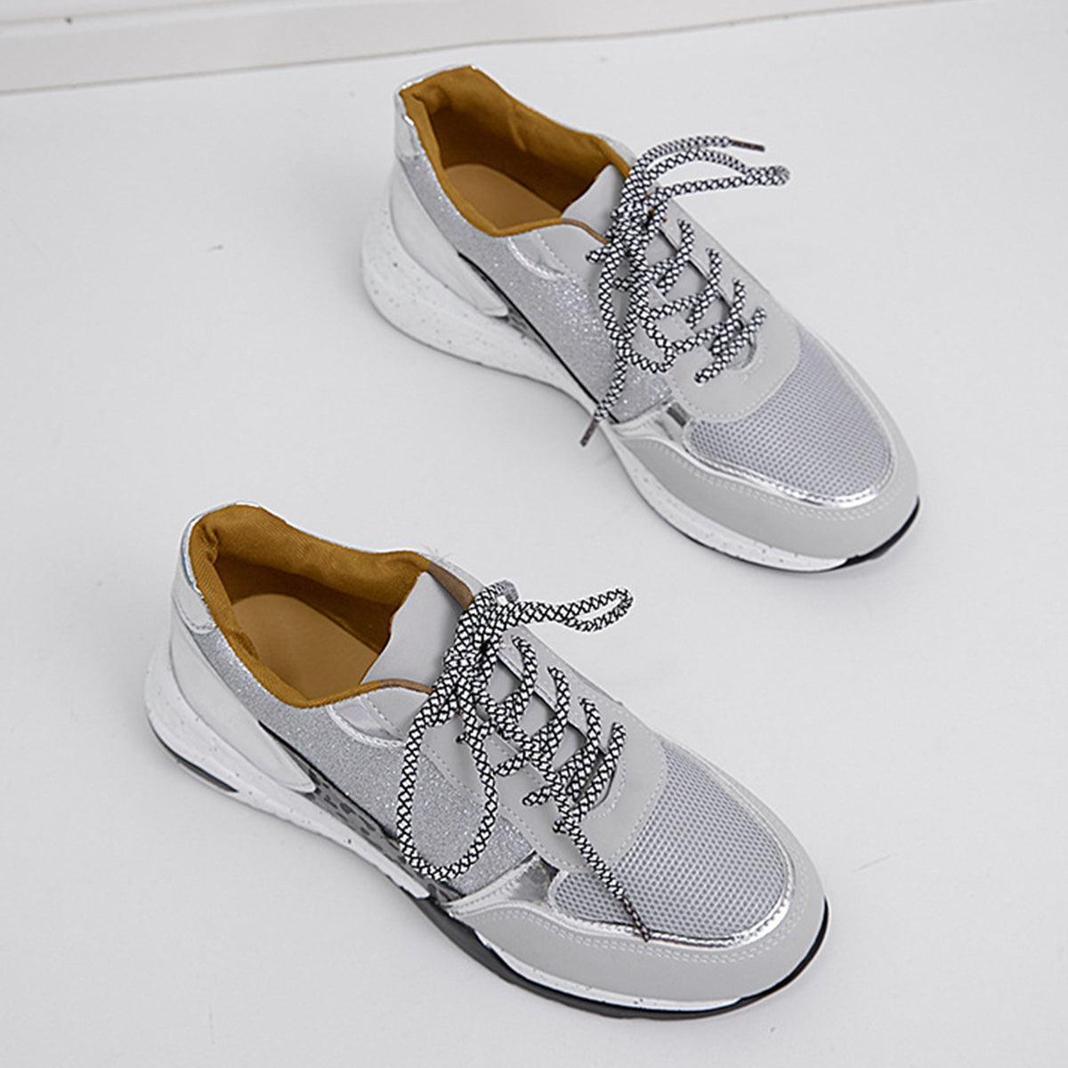 a pair of silver shoes sitting on top of a white floor