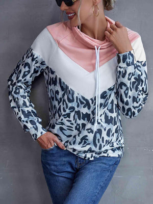 a woman wearing a leopard print hoodie and jeans