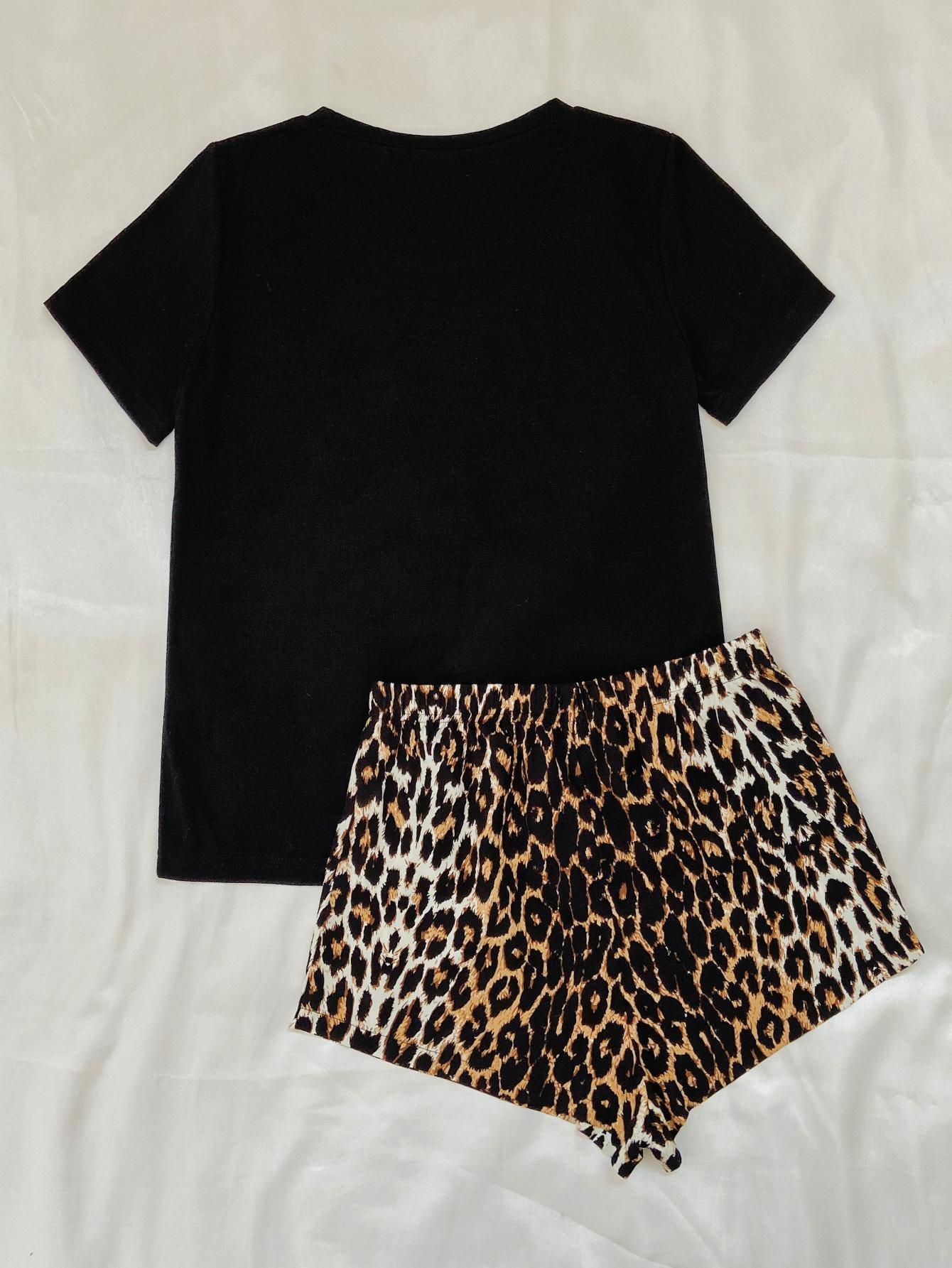 a black shirt and leopard print shorts on a bed