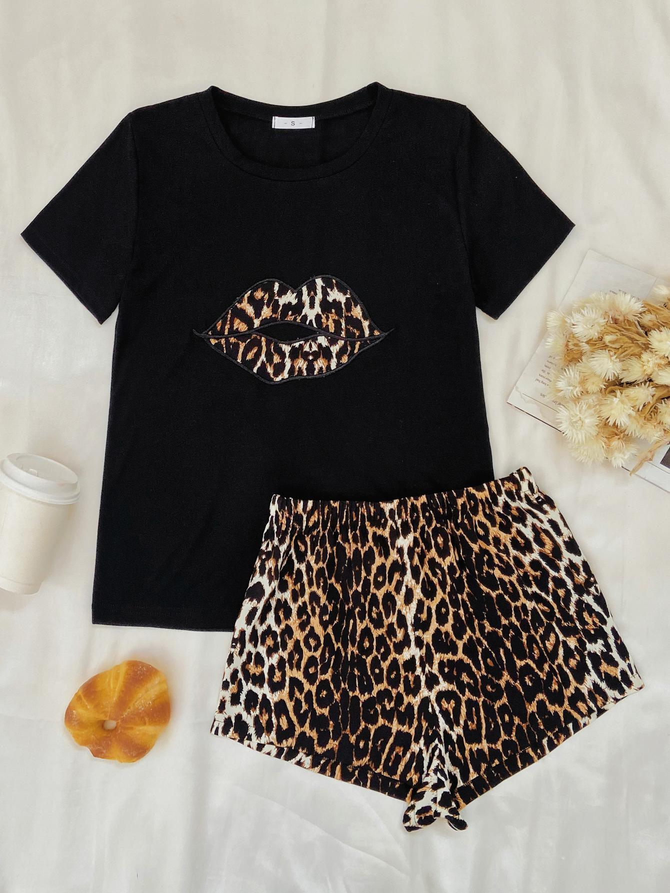 a black shirt and leopard print shorts on a bed