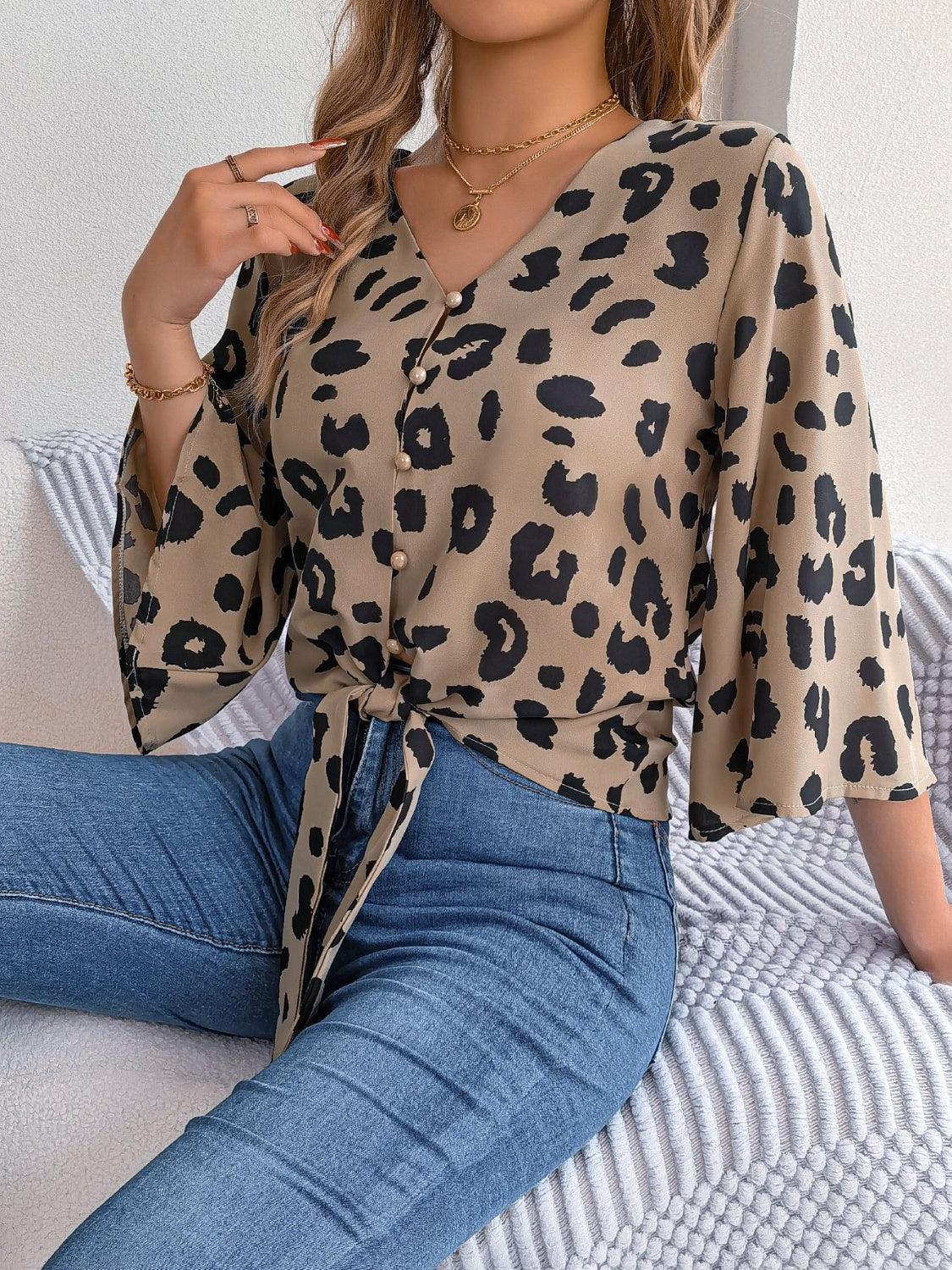 a woman sitting on top of a bed wearing a leopard print shirt