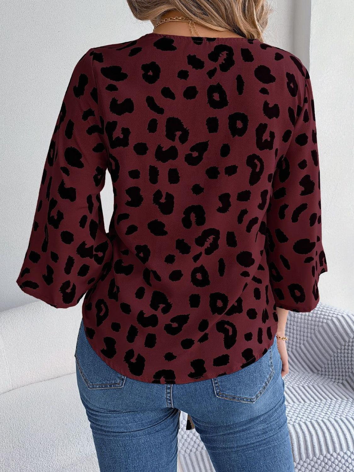 a woman wearing a red and black top with a leopard print