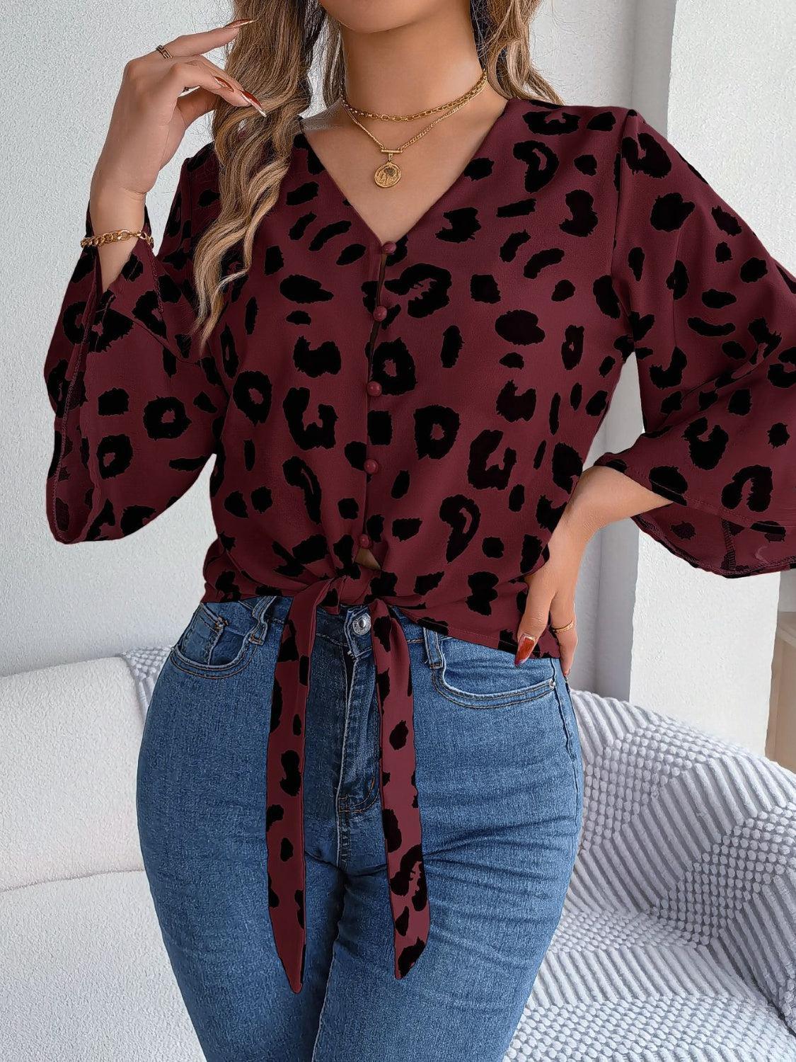 a woman wearing a leopard print blouse and jeans