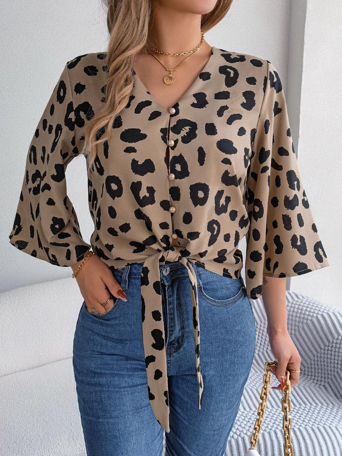 a woman wearing a leopard print shirt and jeans