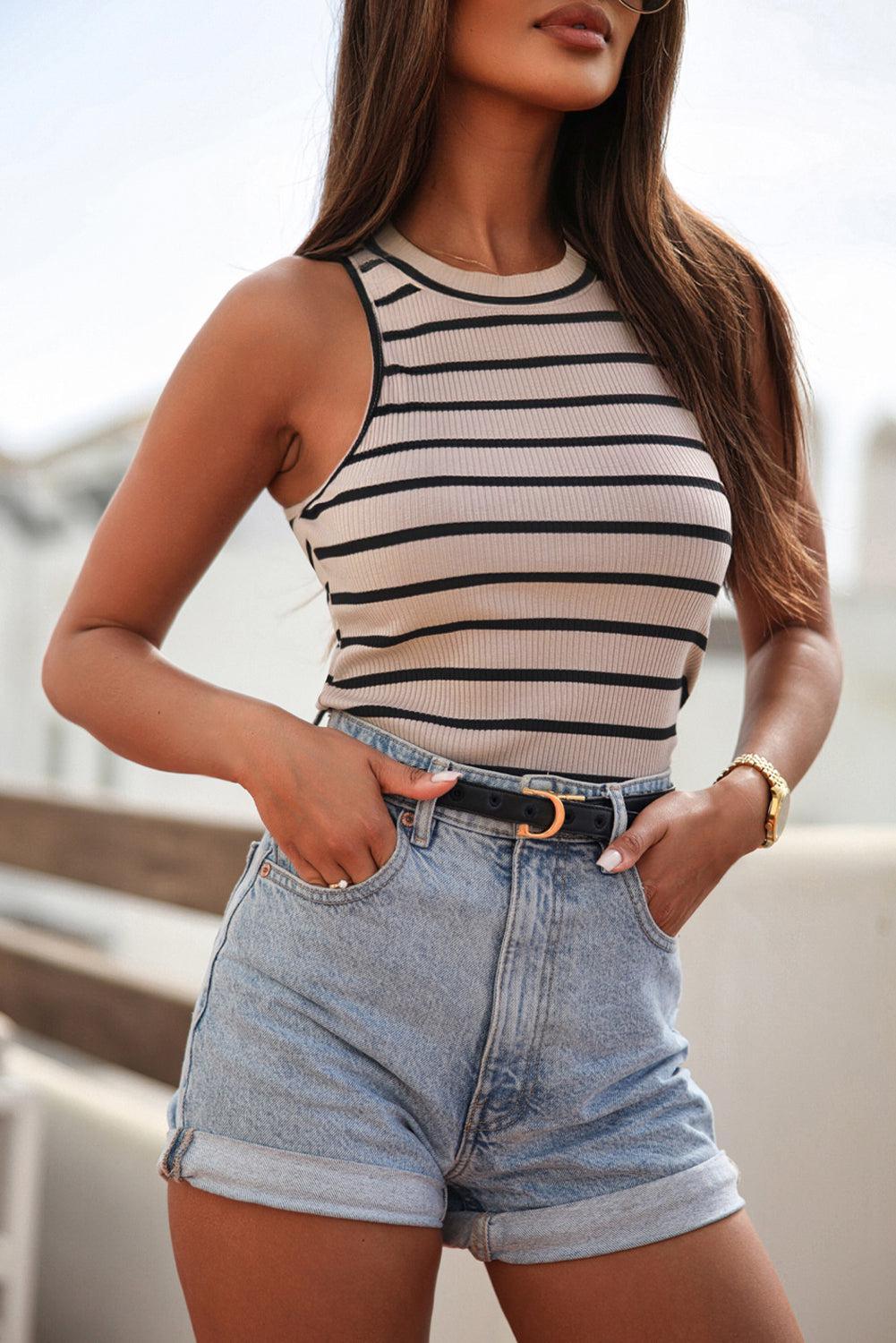 a woman wearing a striped top and denim shorts