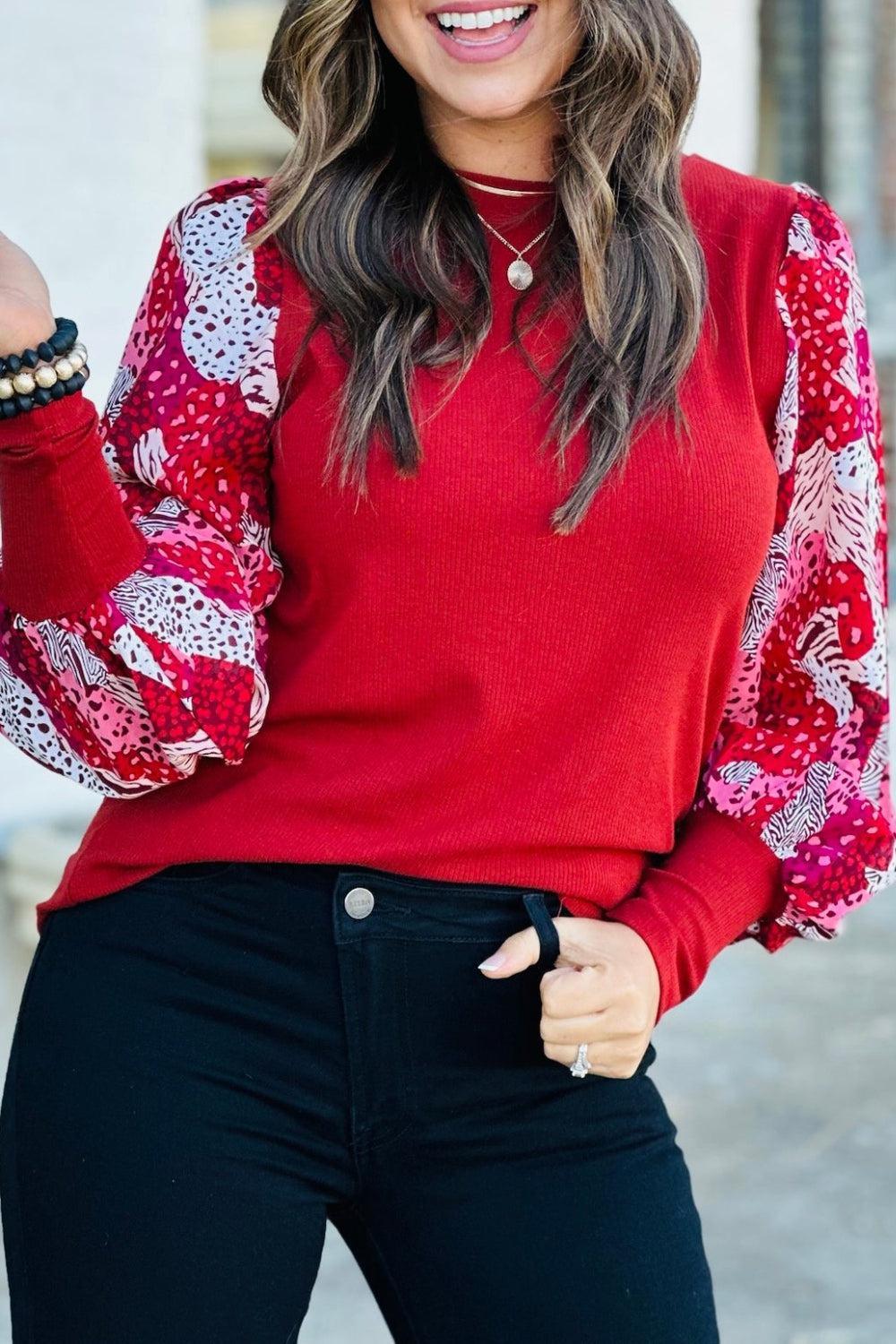 a woman wearing a red sweater and black pants