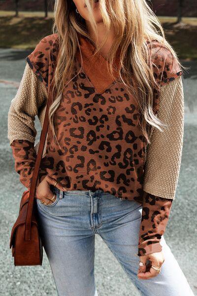 a woman wearing a leopard print sweater and jeans