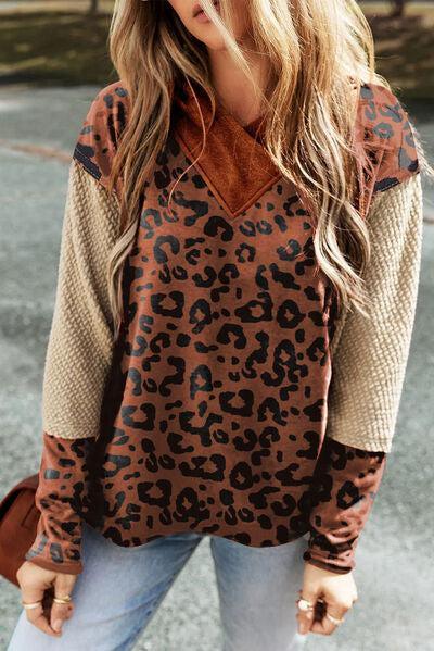 a woman wearing a leopard print sweater and jeans