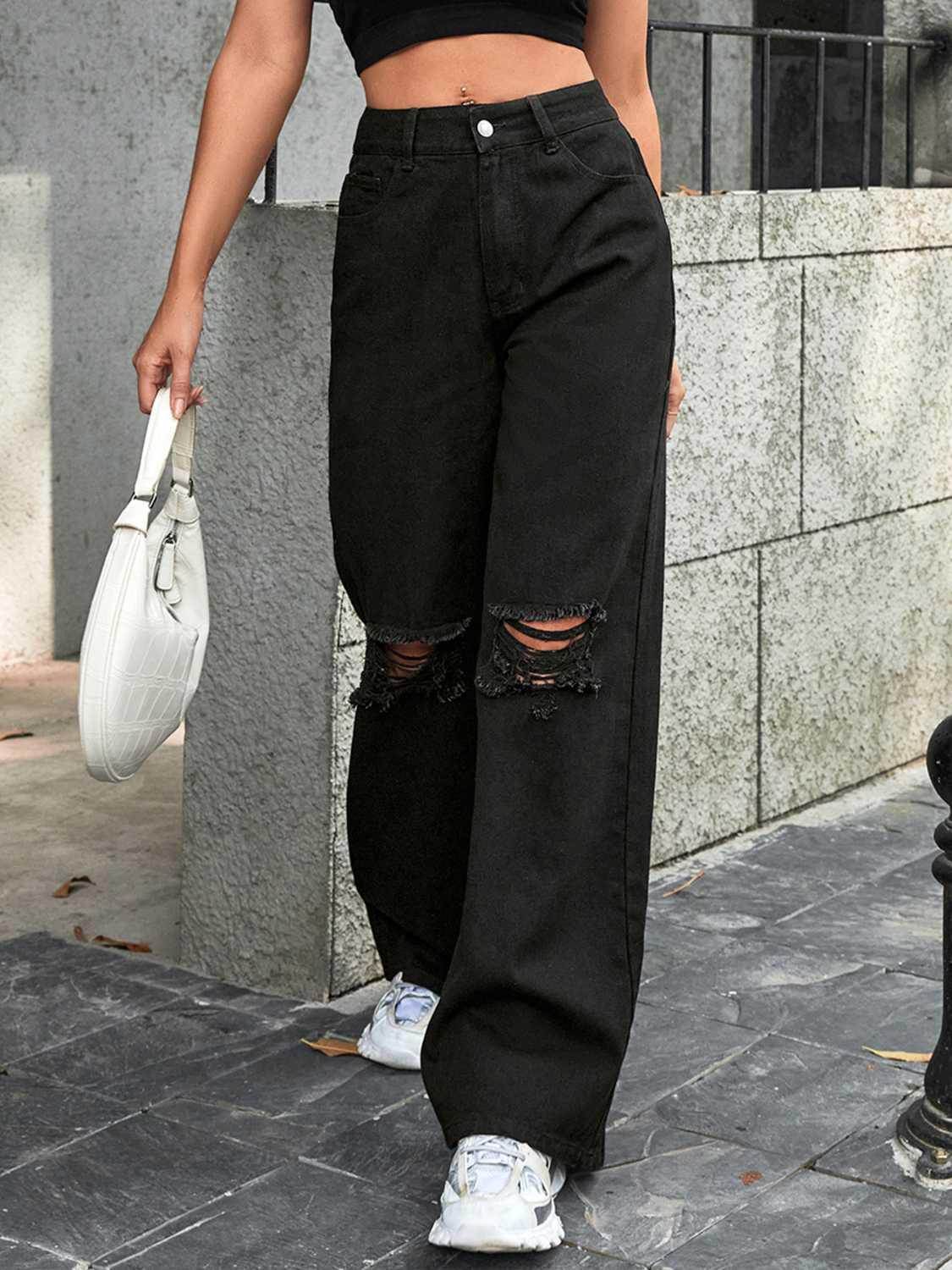 a woman standing on a sidewalk with her hand in her pocket