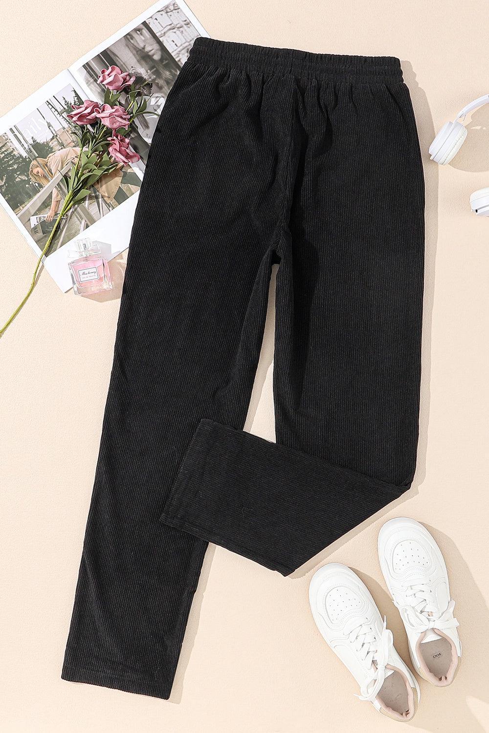 a pair of black pants next to a pair of white shoes