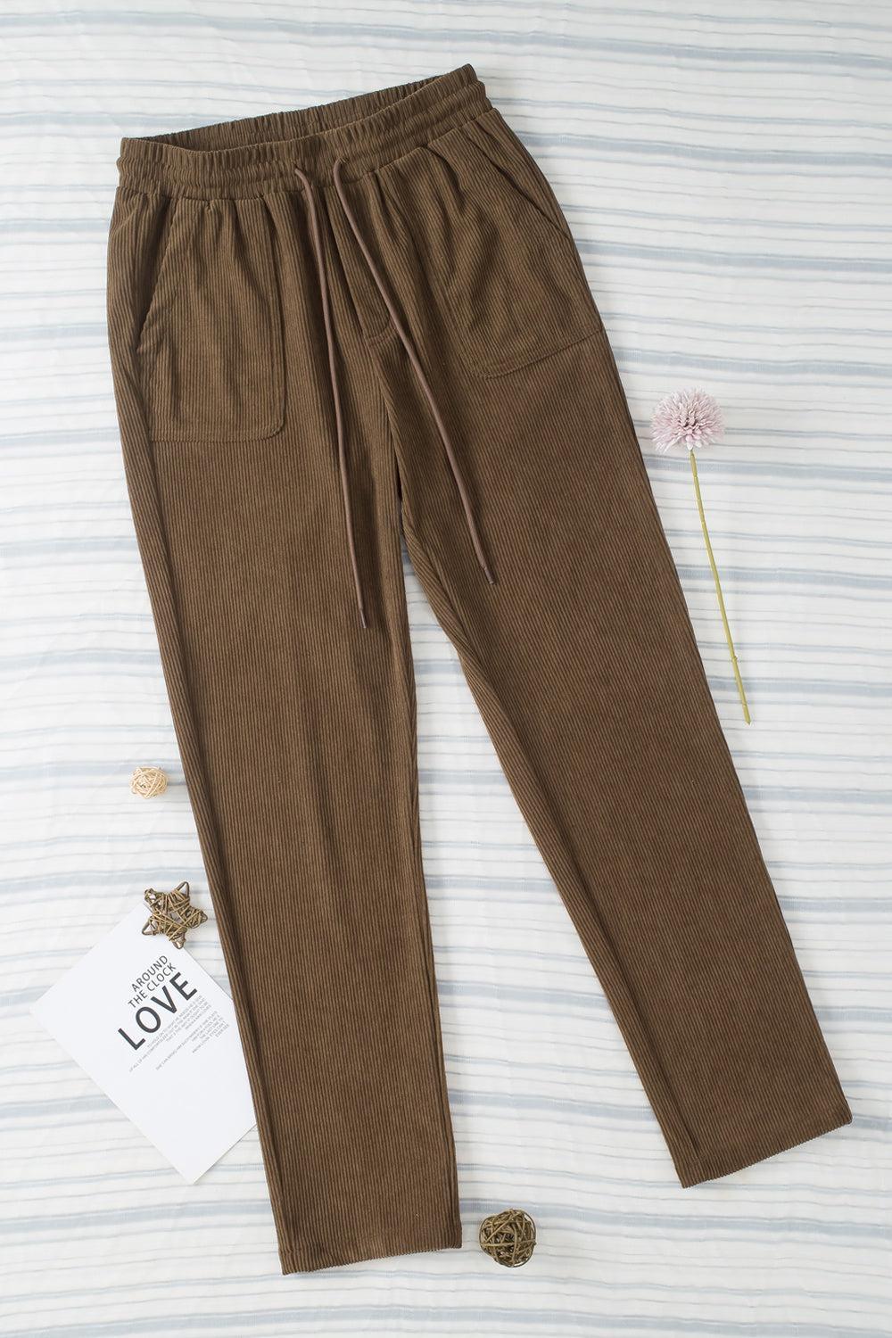 a pair of brown pants sitting on top of a bed