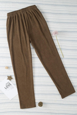 a pair of brown pants sitting on top of a bed