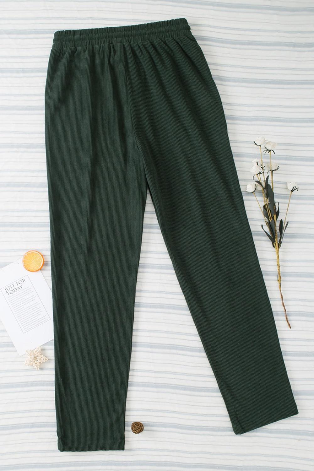 a pair of green pants sitting on top of a bed