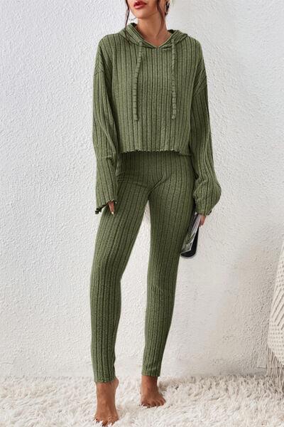 a woman wearing a green sweater and pants