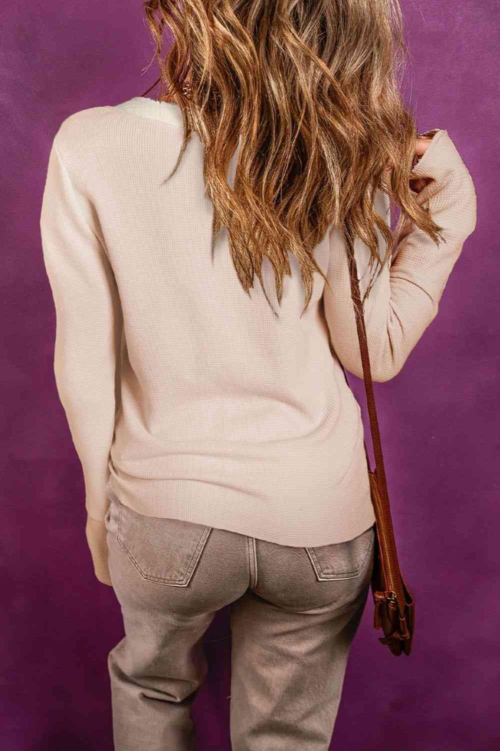 the back of a woman's head wearing a sweater and pants