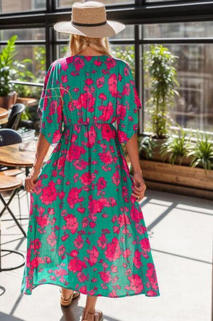 a woman wearing a green and pink floral print dress