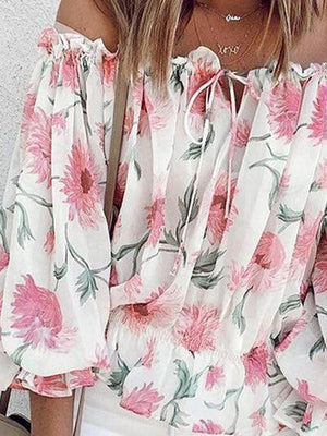 a woman wearing a floral blouse and white shorts