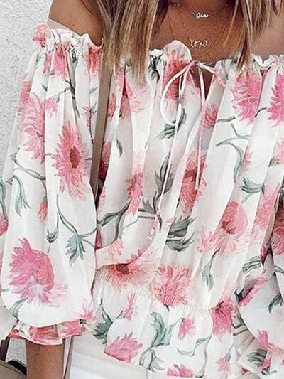 a woman wearing a floral blouse and white shorts