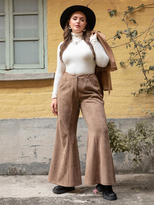 a woman in a white top and brown pants