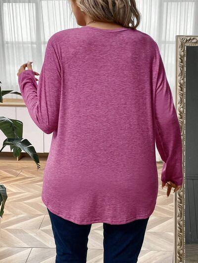 a woman standing in front of a mirror wearing a pink top