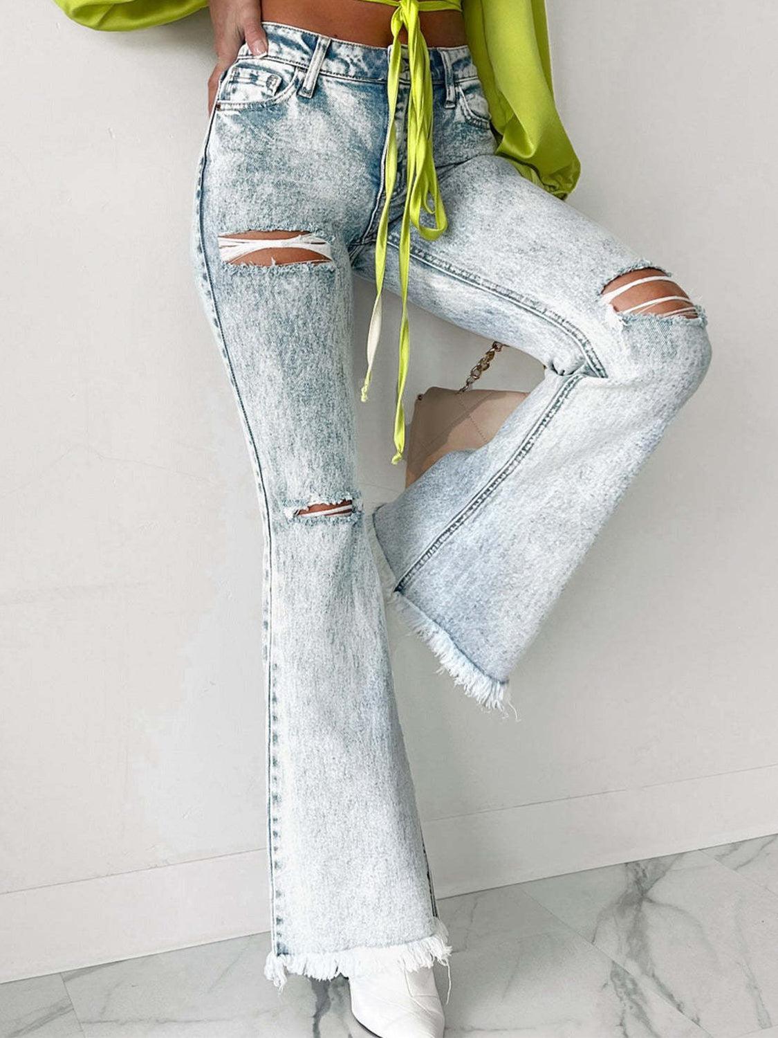 a woman wearing ripped jeans and a green top