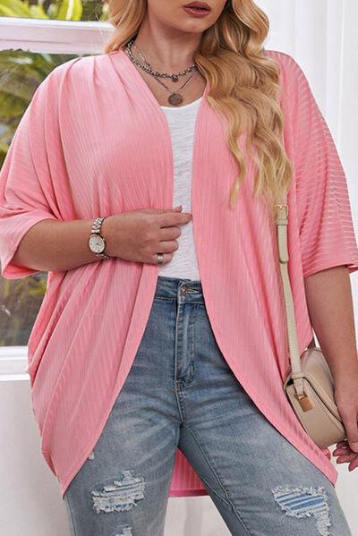 a woman wearing a pink cardigan and ripped jeans