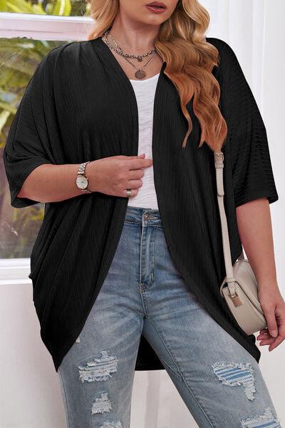 a woman wearing ripped jeans and a black cardigan