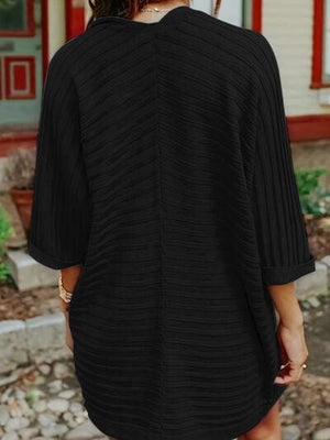 a woman wearing a black sweater dress