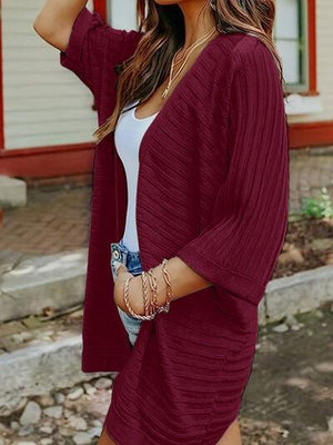 a woman wearing a red cardigan sweater and shorts