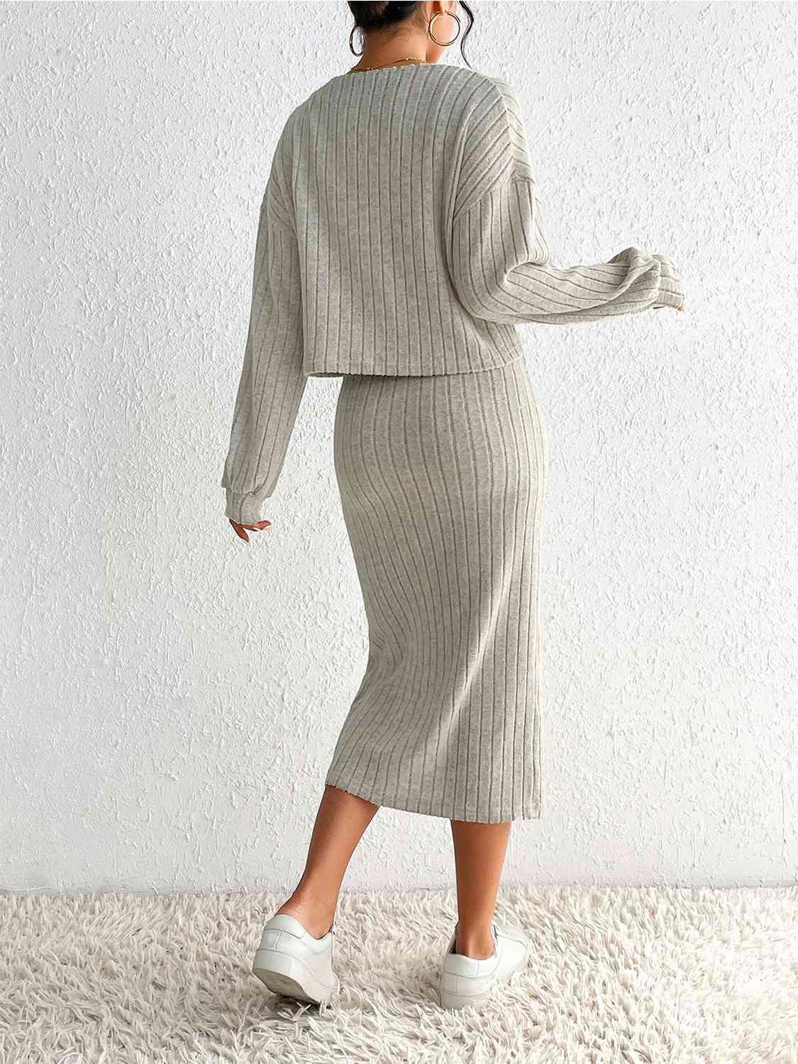 a woman in a grey sweater and skirt