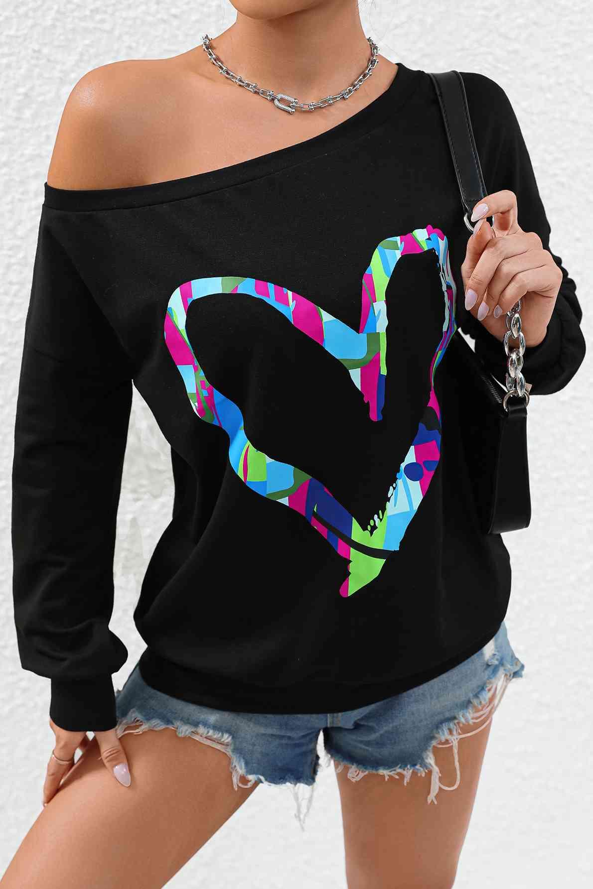 a woman wearing a black shirt with a colorful heart on it
