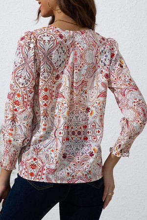 a woman wearing a blouse with a paisley pattern