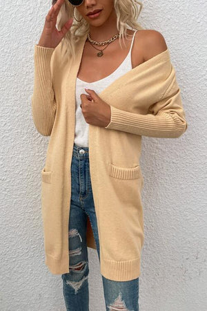 a woman wearing ripped jeans and a cardigan sweater