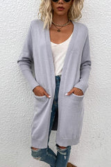 a woman wearing a gray cardigan sweater and ripped jeans