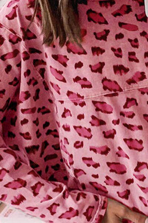 a woman wearing a pink and red leopard print pajamas