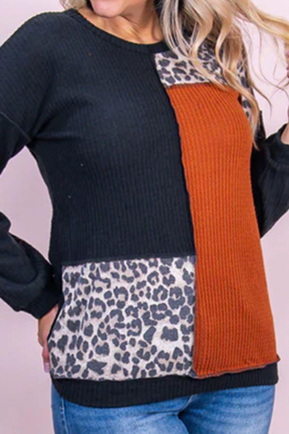 a woman wearing a black and orange sweater