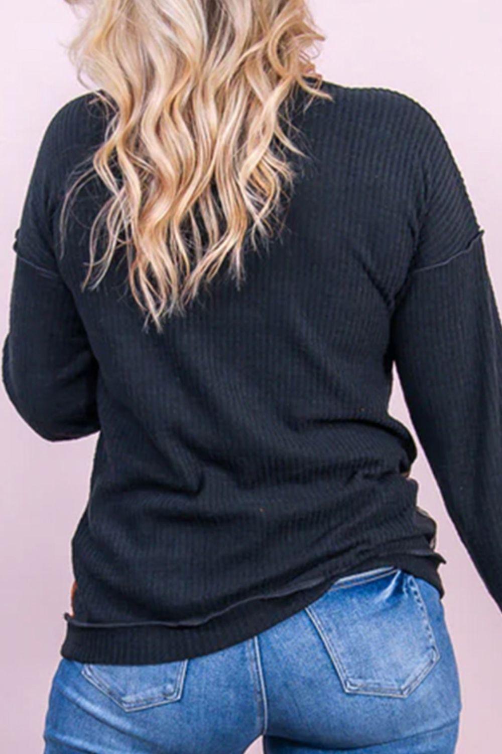 a woman wearing a black sweater and jeans