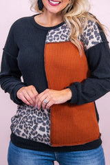 a woman wearing a leopard print and black sweater