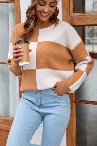 a woman wearing a brown and white striped sweater and jeans
