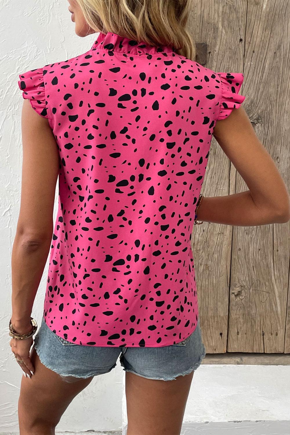 a woman wearing a pink top with black spots