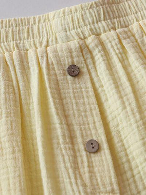 a close up of a yellow skirt with buttons