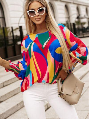 a woman wearing white pants and a colorful top