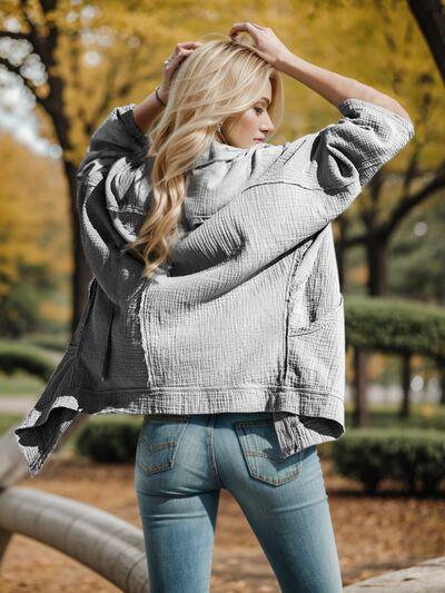 a woman standing in a park with her hands on her head