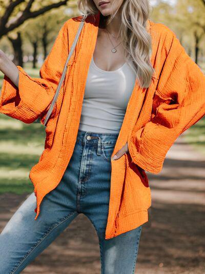 a woman in an orange cardigan posing for a picture