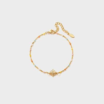 a gold bracelet with a heart charm on a white background