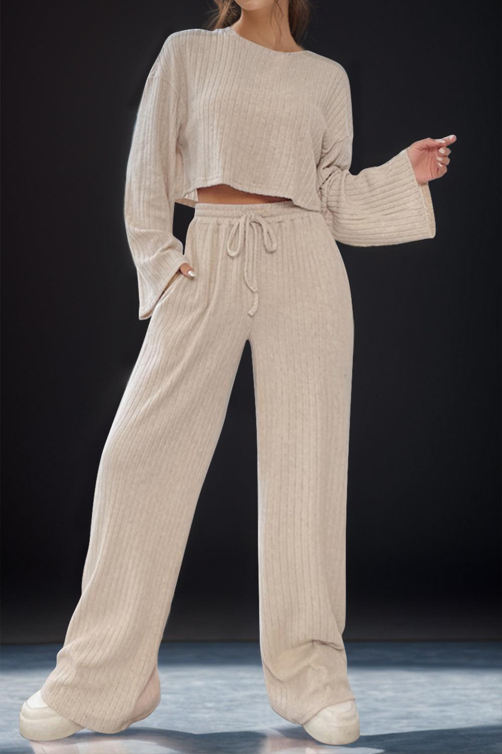 a woman in a cropped sweater and wide legged pants