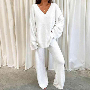 a woman wearing a white sweater and pants